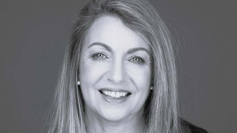Kerry Sarten, Chair of the Board at Ten Days on the Island. Warm expression, pearl earrings, the quiet confidence of someone who keeps meetings on time.