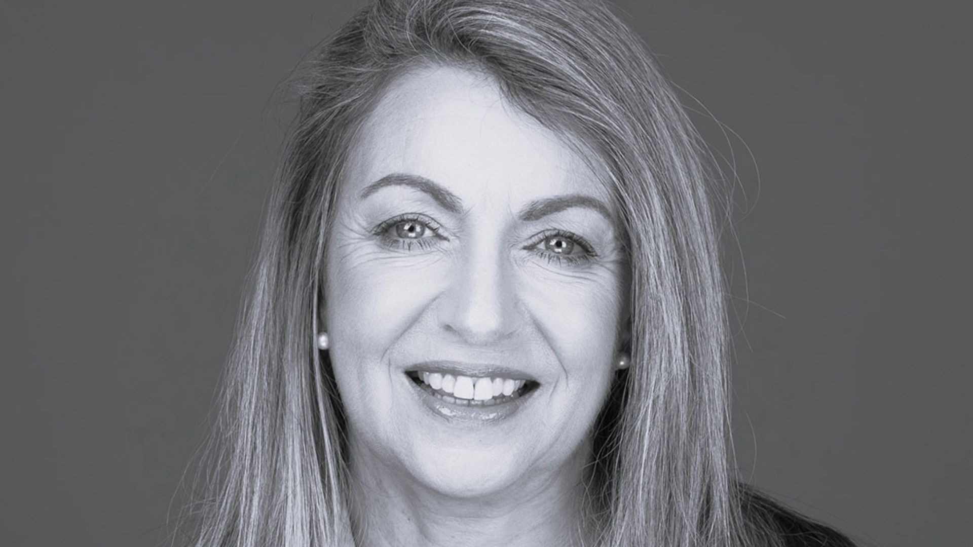 Kerry Sarten, Chair of the Board at Ten Days on the Island. Warm expression, pearl earrings, the quiet confidence of someone who keeps meetings on time.
